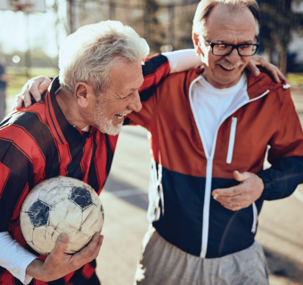 Two active senior men playing soccer