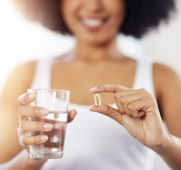 woman taking fish oil supplement