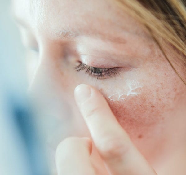woman putting moisturizer on her face