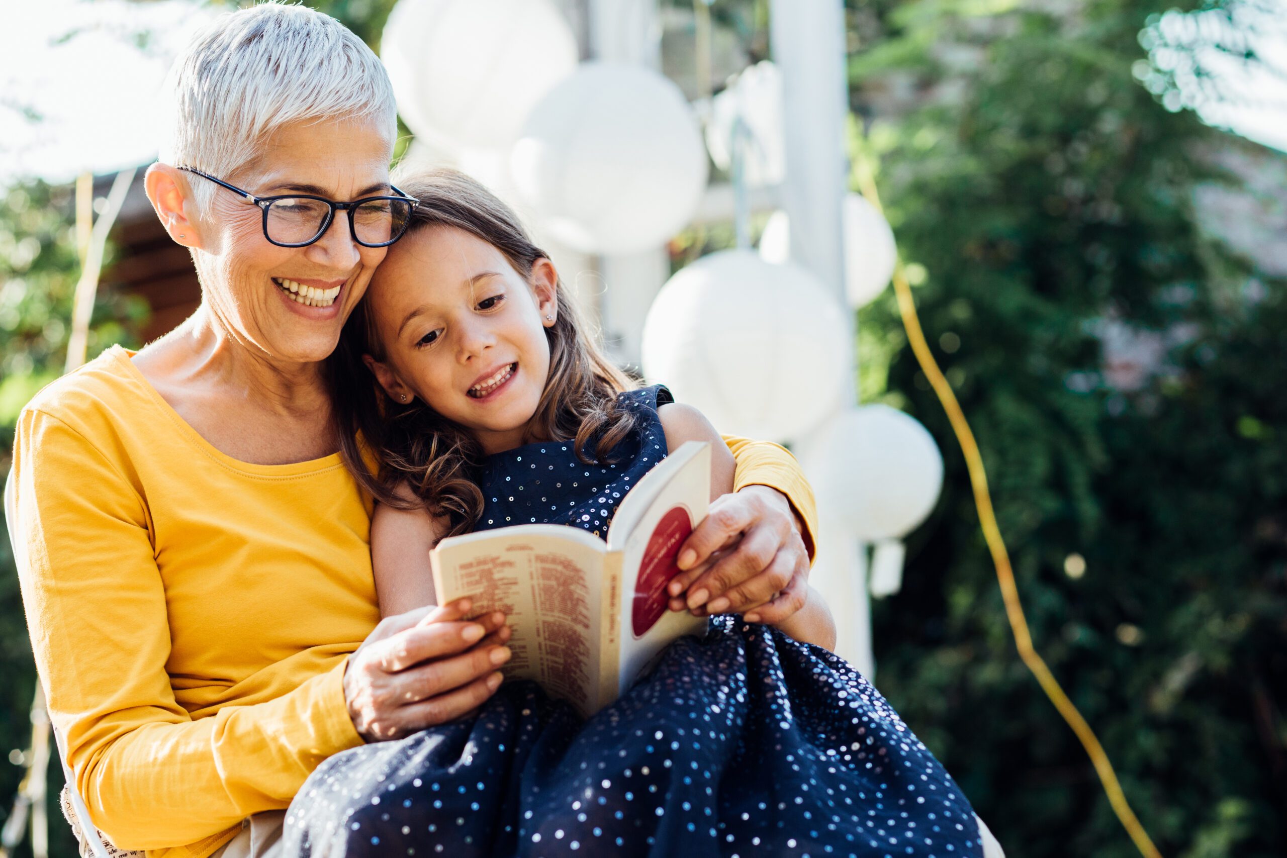 smiling-woman-reading-to-granddaughter