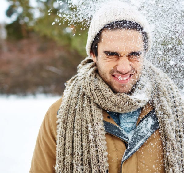 man squinting in the snow winter eye conditions